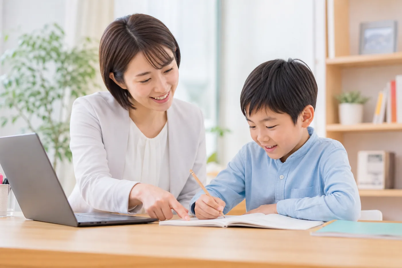 家庭教師の先生と生徒がノートを見ながら学習している写真